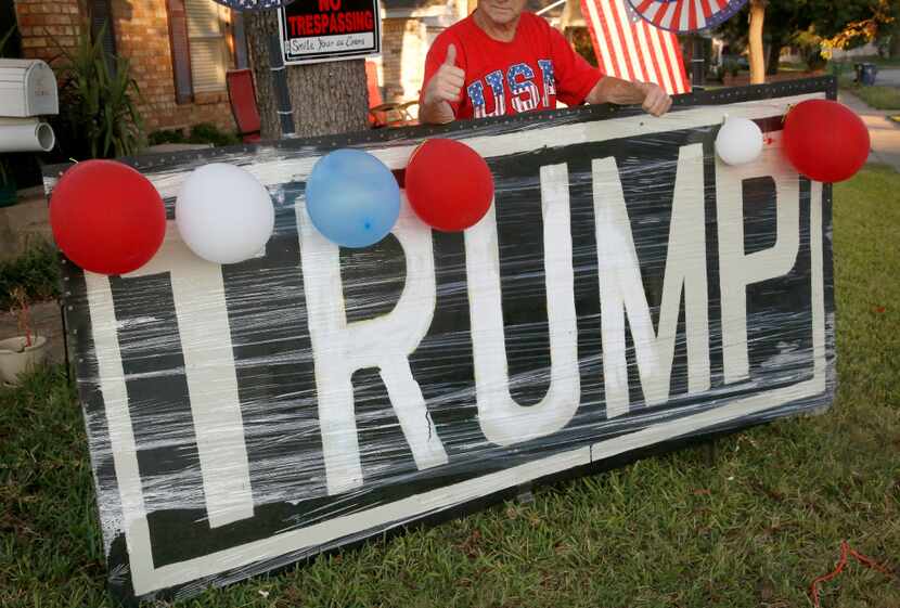 Jerry Tarter gives a thumbs up as he poses behind a big Donald Trump sign he made with...