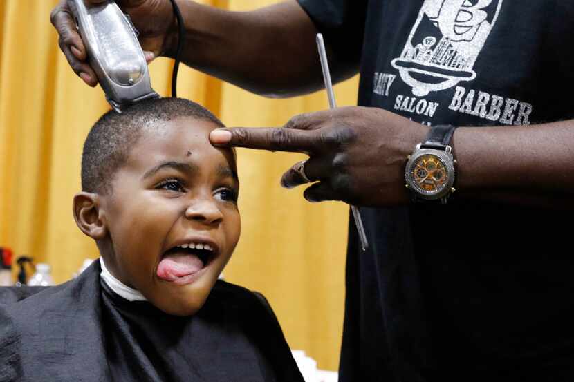 Nathaniel Wilson, 5, was all smiles as Cedric Bolden of Cedric B'­s Barber and Beauty Salon...