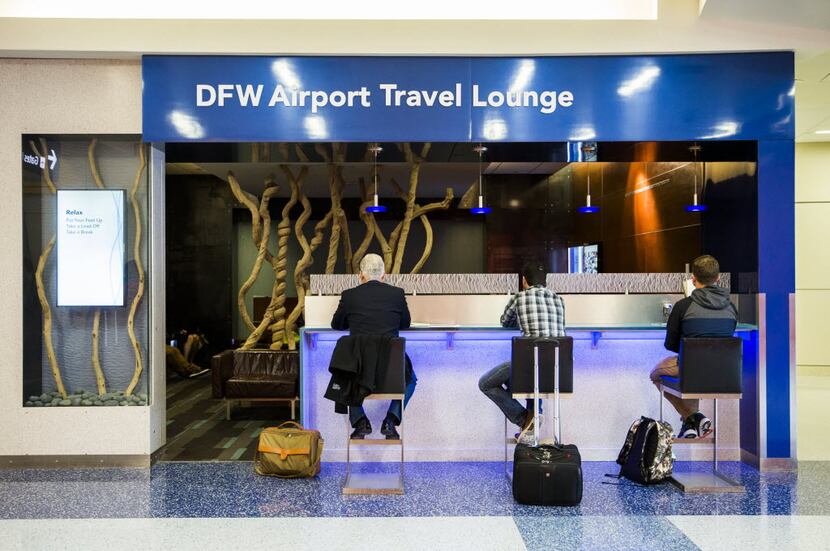 Travelers sit and charge their phones at DFW Airport Travel Lounge on Thursday, May 21, 2015...