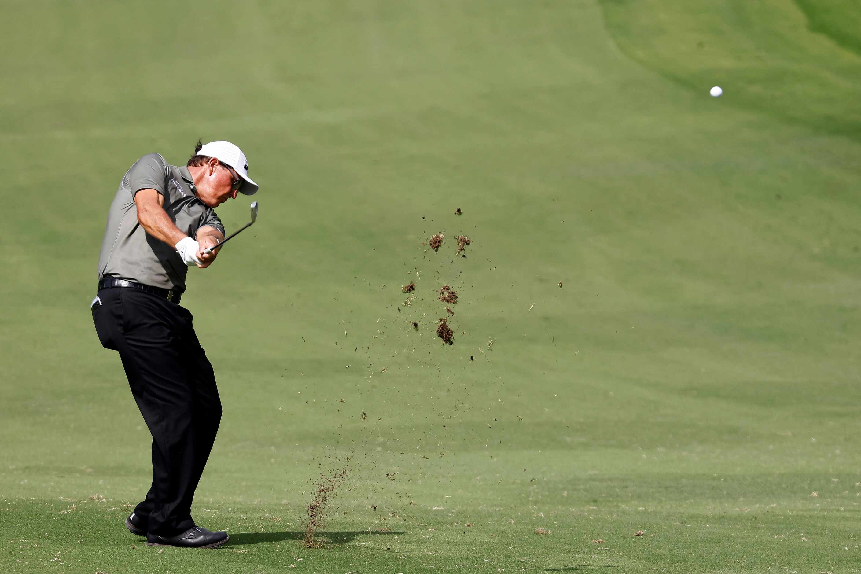 Professional golfer Phil Mickelson makes his approach shot on No.18 during round one of the...