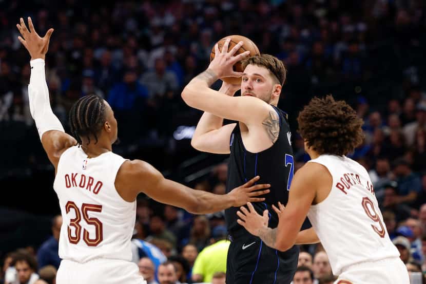 Dallas Mavericks guard Luka Doncic (77) looks to pass out of a double team from Cleveland...