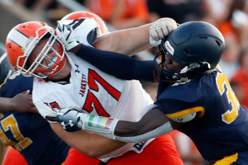 Highland Park defensive lineman Prince Dorbah (32) battles with Rockwall offensive lineman...