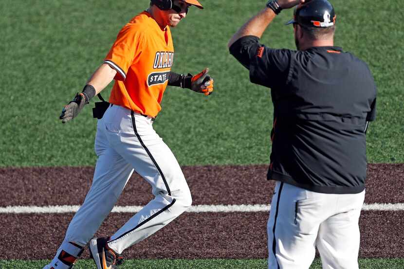 Oklahoma State's Hueston Morrill (1) reaches out to assistant coach James Vilade after...