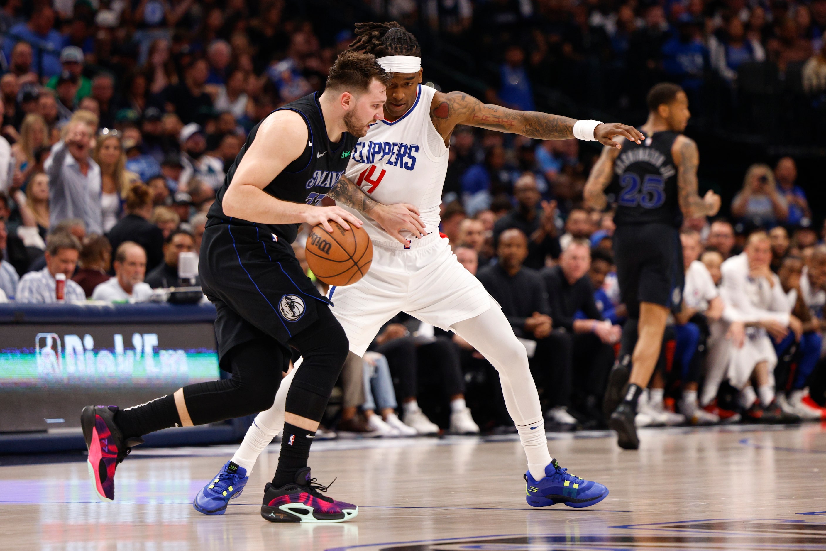 Dallas Mavericks guard Luka Doncic (77) dribbles up court against LA Clippers guard Terance...