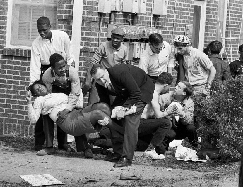 Amelia Boynton is carried and another injured man tended to after they were injured when...