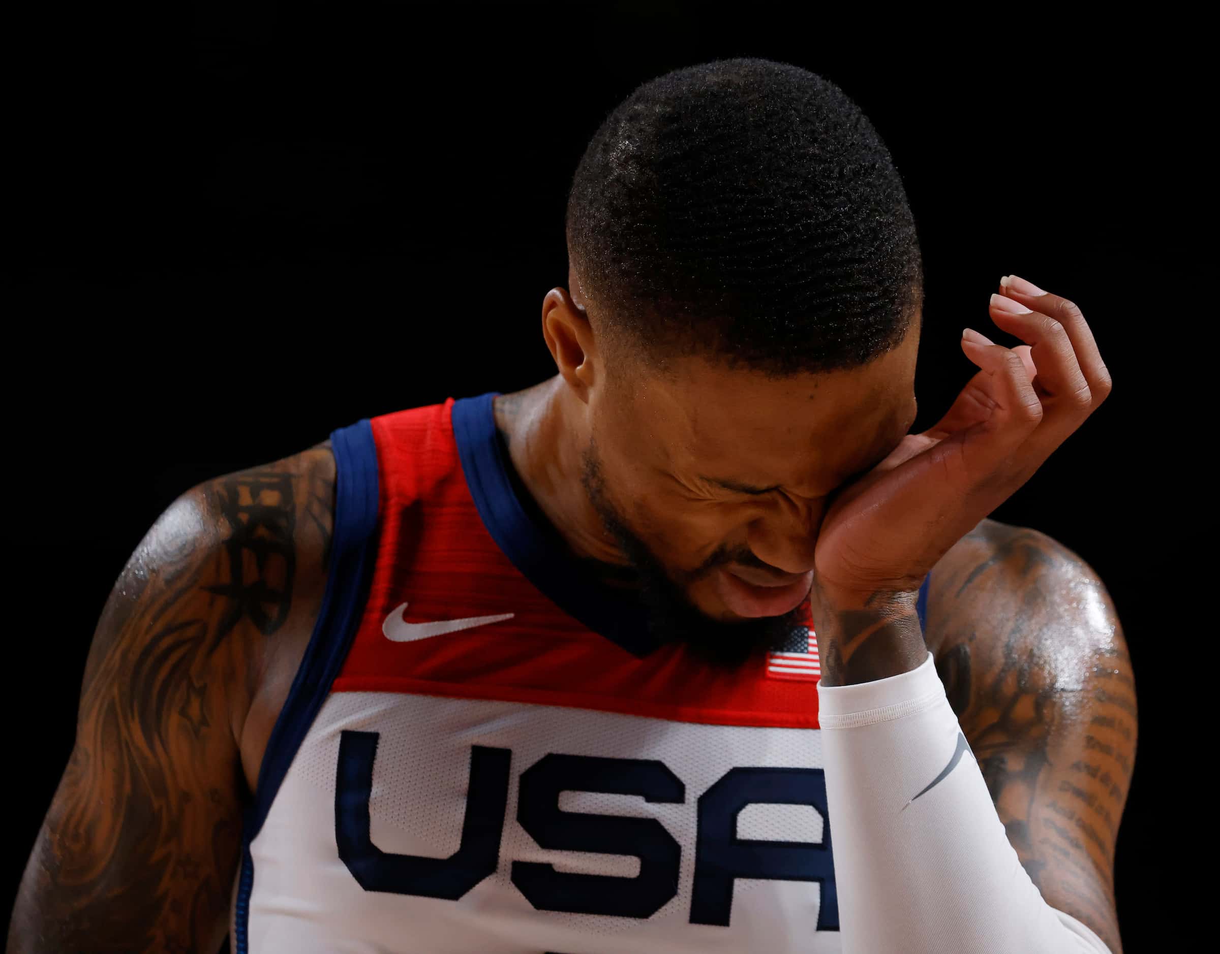 USA’s Damian Lillard (6) rubs his eye after getting hit in the face on a drive in a game...
