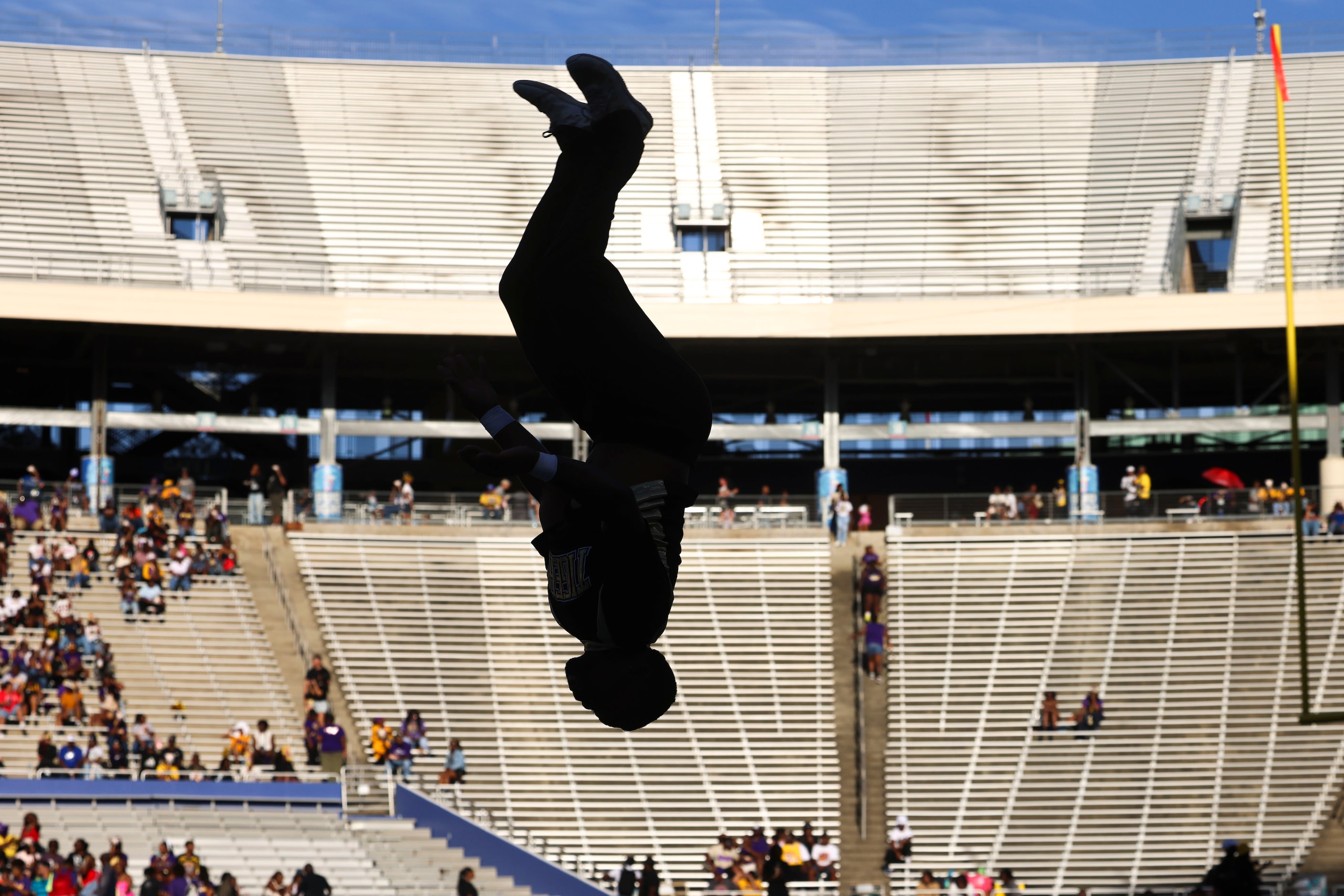 A Grambling State cheer member is silhouetted as he prepares ahead of the first half of...