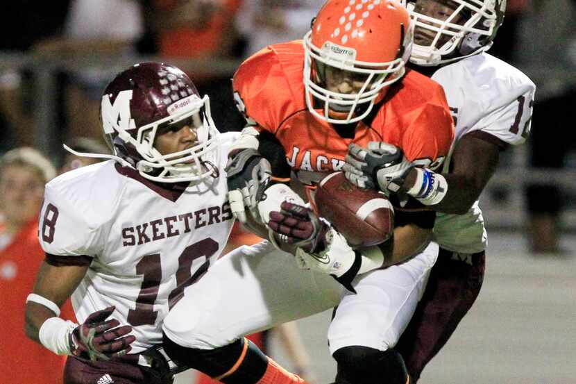 Rockwall High's Xavier Castille (22) catches a pass, as Mesquite High defenders Traa Strong...