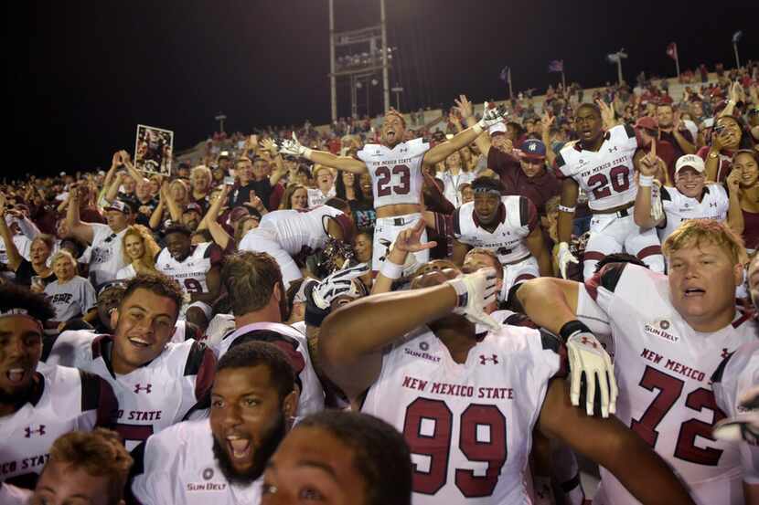 New Mexico State players celebrate near their fan section after defeating New Mexico 30-28...