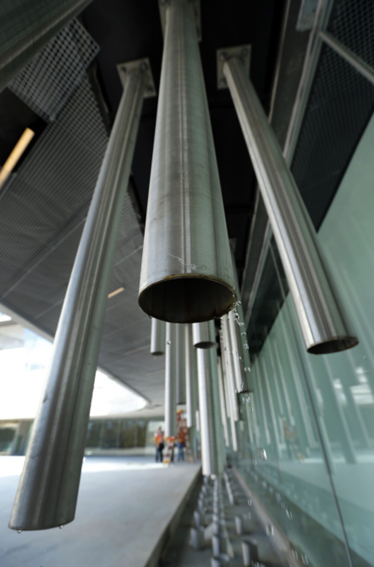 Rain tubes near the main entrance channel rainwater from the roof for collection in two...