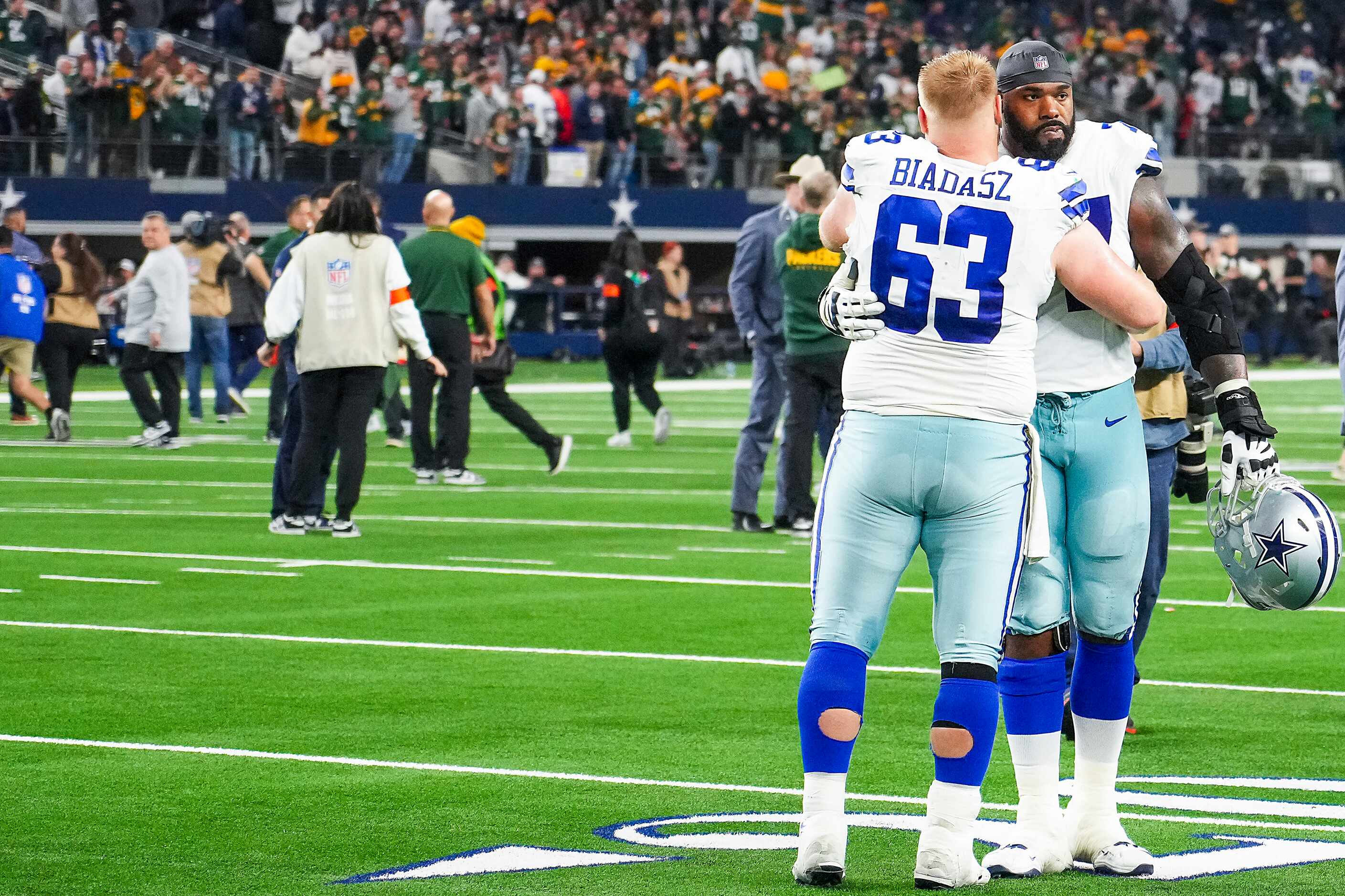 Dallas Cowboys offensive tackle Tyron Smith (77) hugs center Tyler Biadasz (63) after a loss...