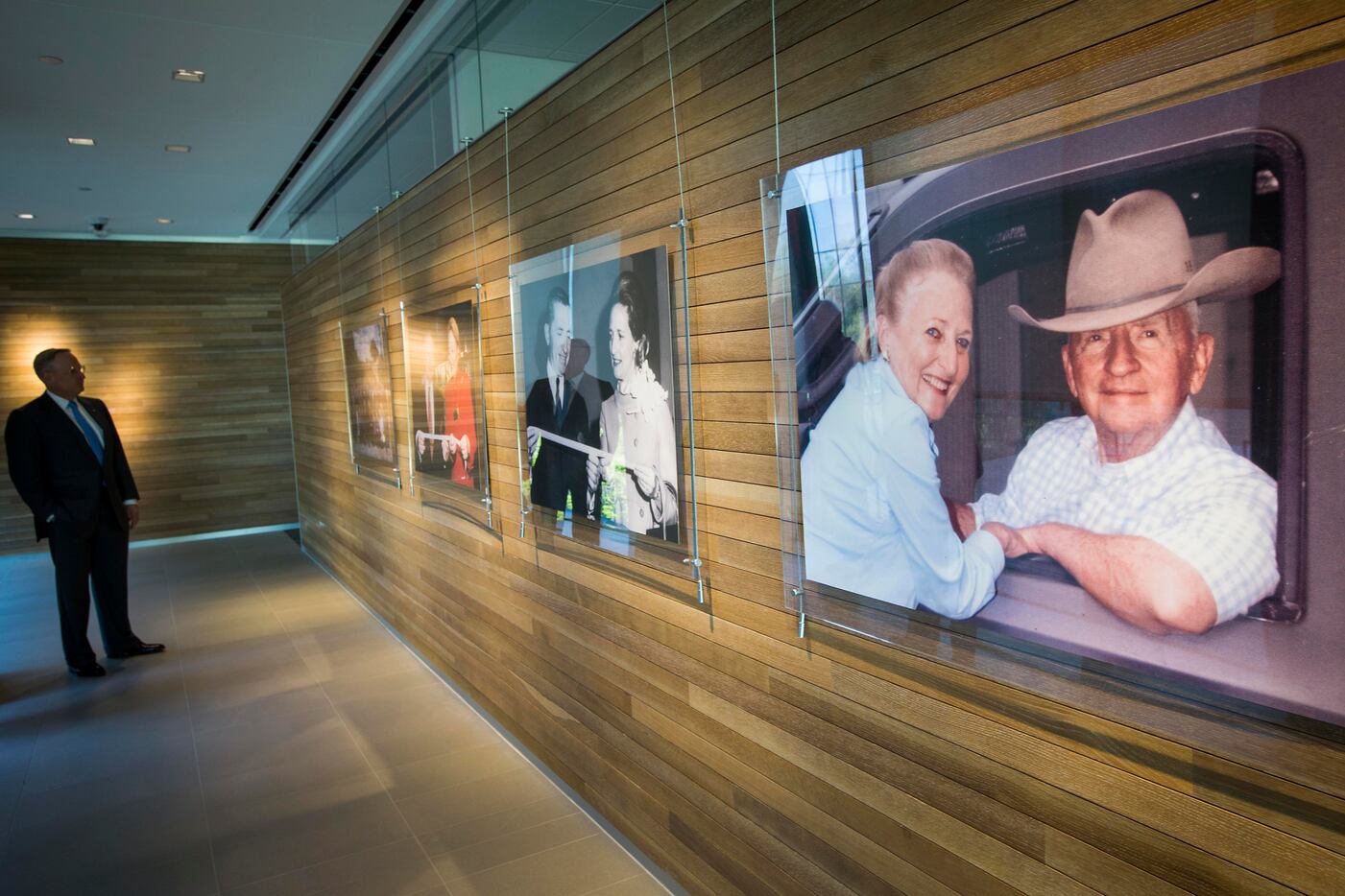 Ross Perot Jr. looks over photographs of his parents while leading a tour of the family's...