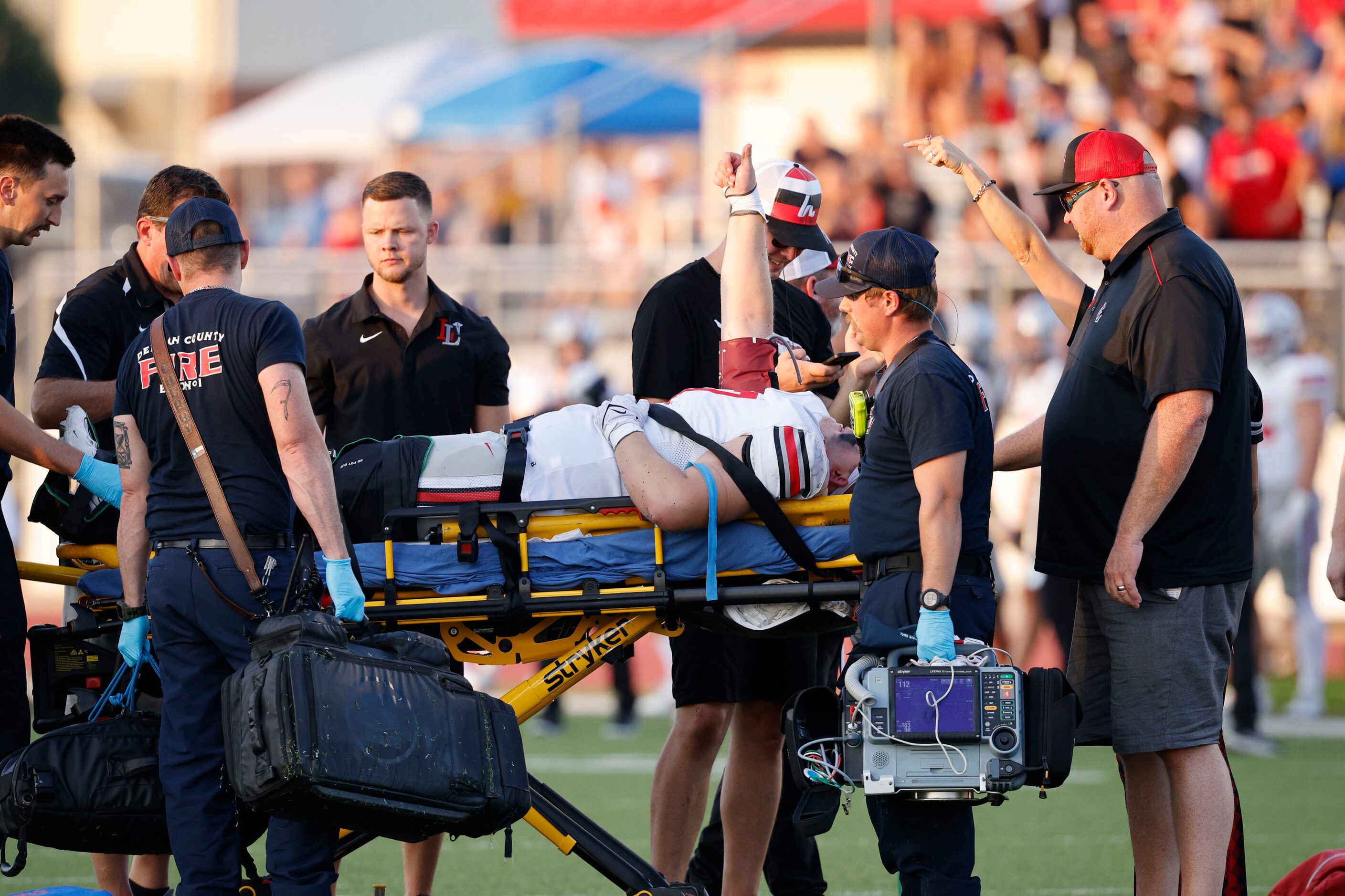 Lovejoy's Tegan Braithwaite (77) gives  the thumbs up when he is carried out from the field...