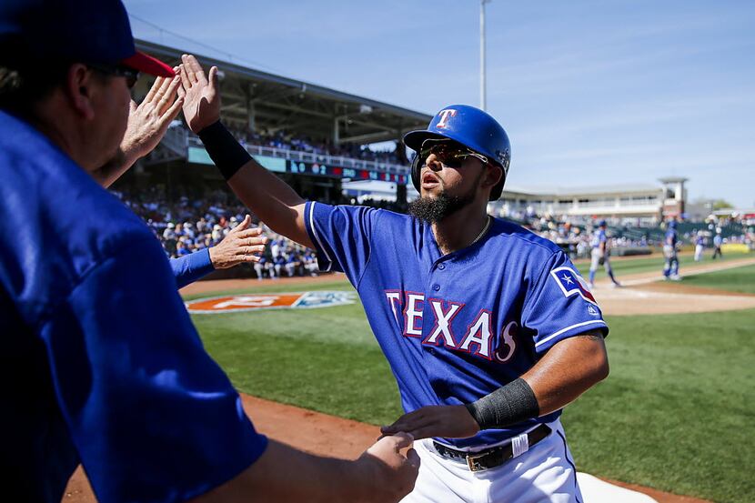 Texas Rangers second baseman Rougned Odor celebrates with coaches after scoring a run during...