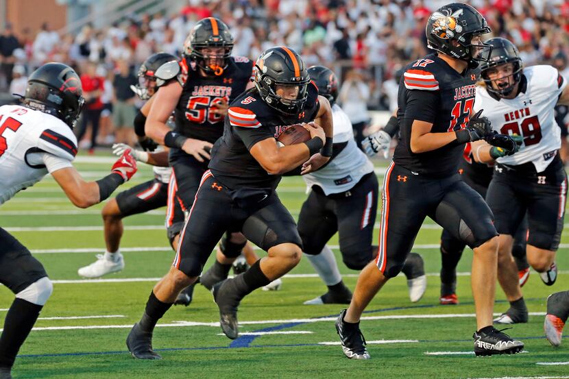 Rockwall high QB Lake Bennett (5) finds a seam and heads to the end zone for a touchdown...