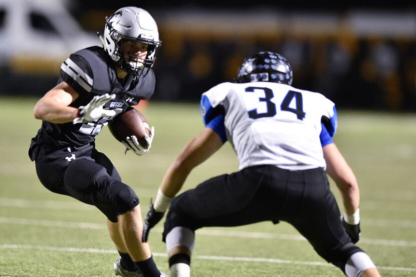 Guyer sophomore wide receiver Seth Meador (19) rushes the ball, while being defended by...