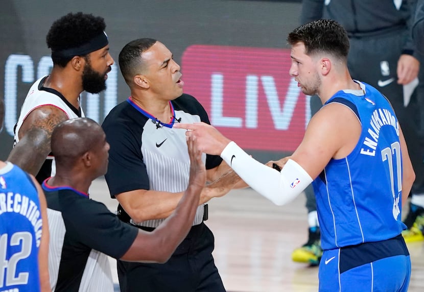 Officials get between Dallas Mavericks' Luka Doncic (77) and Los Angeles Clippers' Marcus...