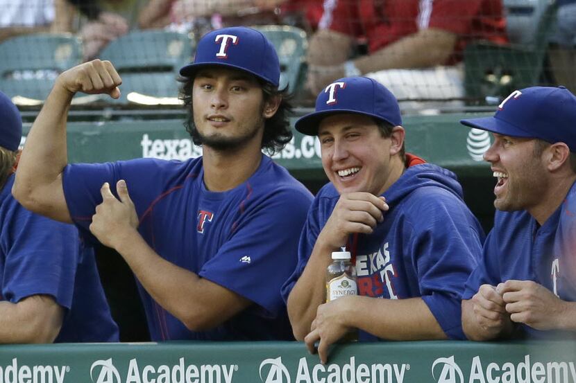 Texas Rangers pitcher Yu Darvish, left, of Japan jokes around with teammates Derek Holland,...