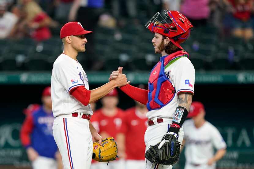 Texas Rangers' Brett Martin, left, and Jonah Heim celebrate the team's 9-7 win in a baseball...