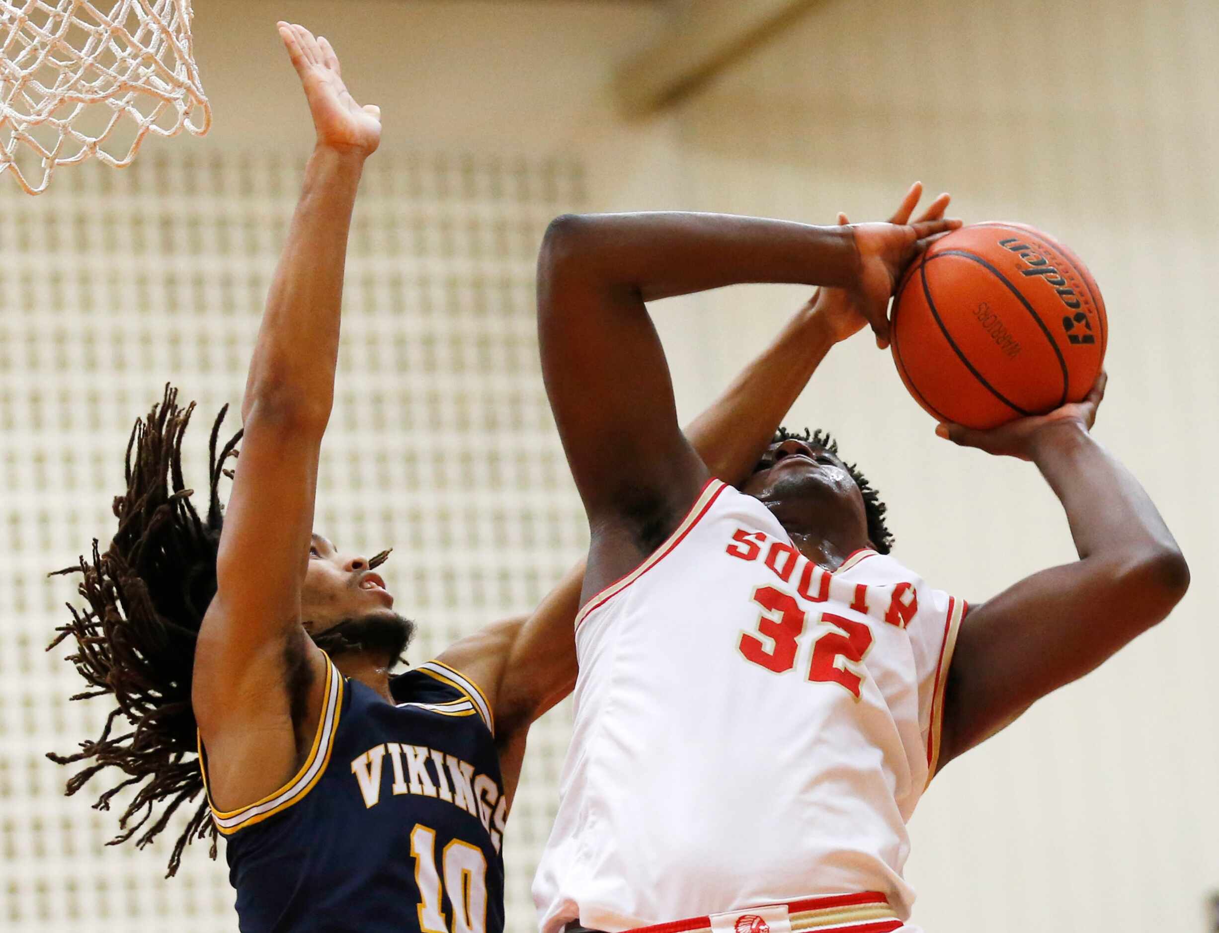 South Grand Prairie's Terin Johnson (32) is fouled on a shot attempt in front of  Arlington...
