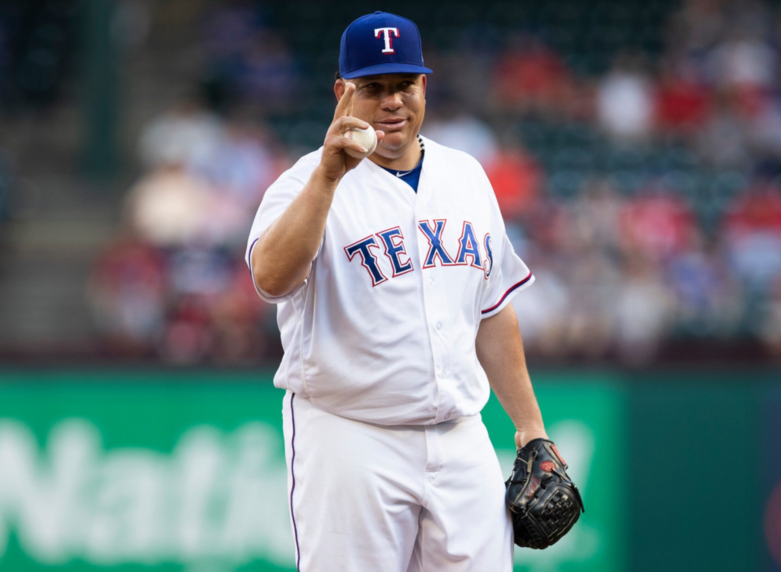 Texas Rangers starting pitcher Bartolo Colon acknowledges the Oakland Athletics bench before...