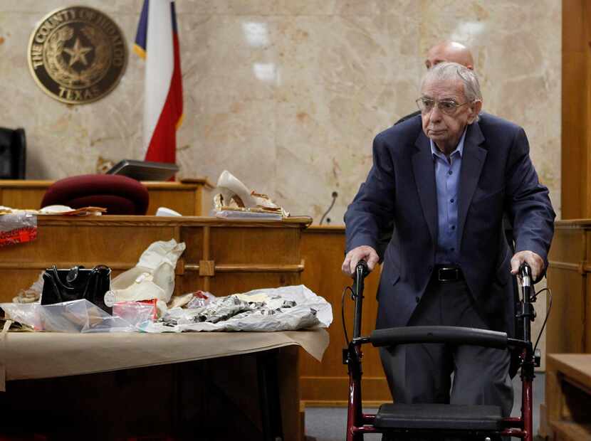 Former priest John Feit walks past clothing worn by Irene Garza in the 92nd state District...