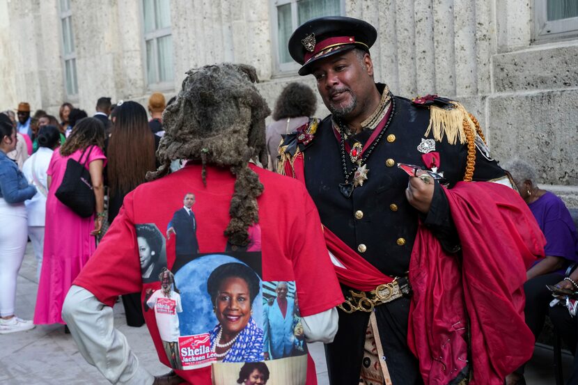 Ben Burns talks with a man named Motapa as they wait to pay their respects to the late Rep....