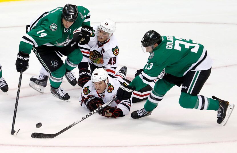 Dallas Stars left wing Jamie Benn (14), Chicago Blackhawks center Jonathan Toews (19),...