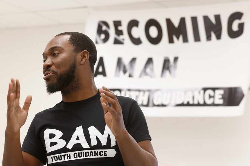 Travis Mason, Becoming a Man (BAM) youth specialist at Pinkston High School, talks with...