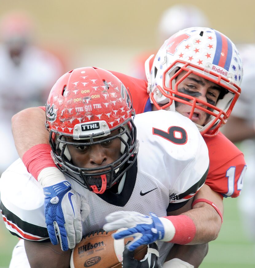 Cedar Hill's Larry Hill (6) runs through a tackle attempt by Waco Midway's Keith Efferson in...