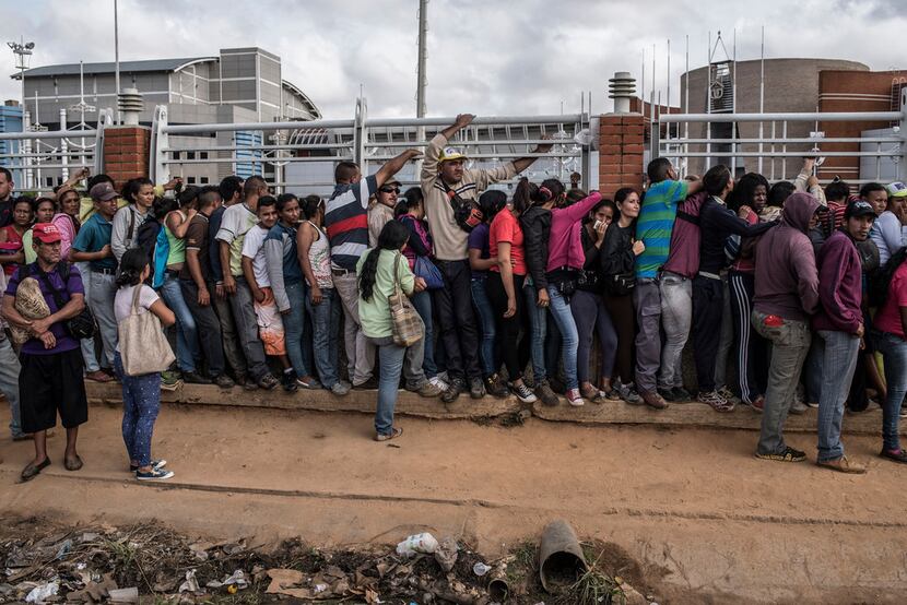 Venezuelans waiting in line outside a supermarket to buy corn meal, in El Tigre, Venezuela,...
