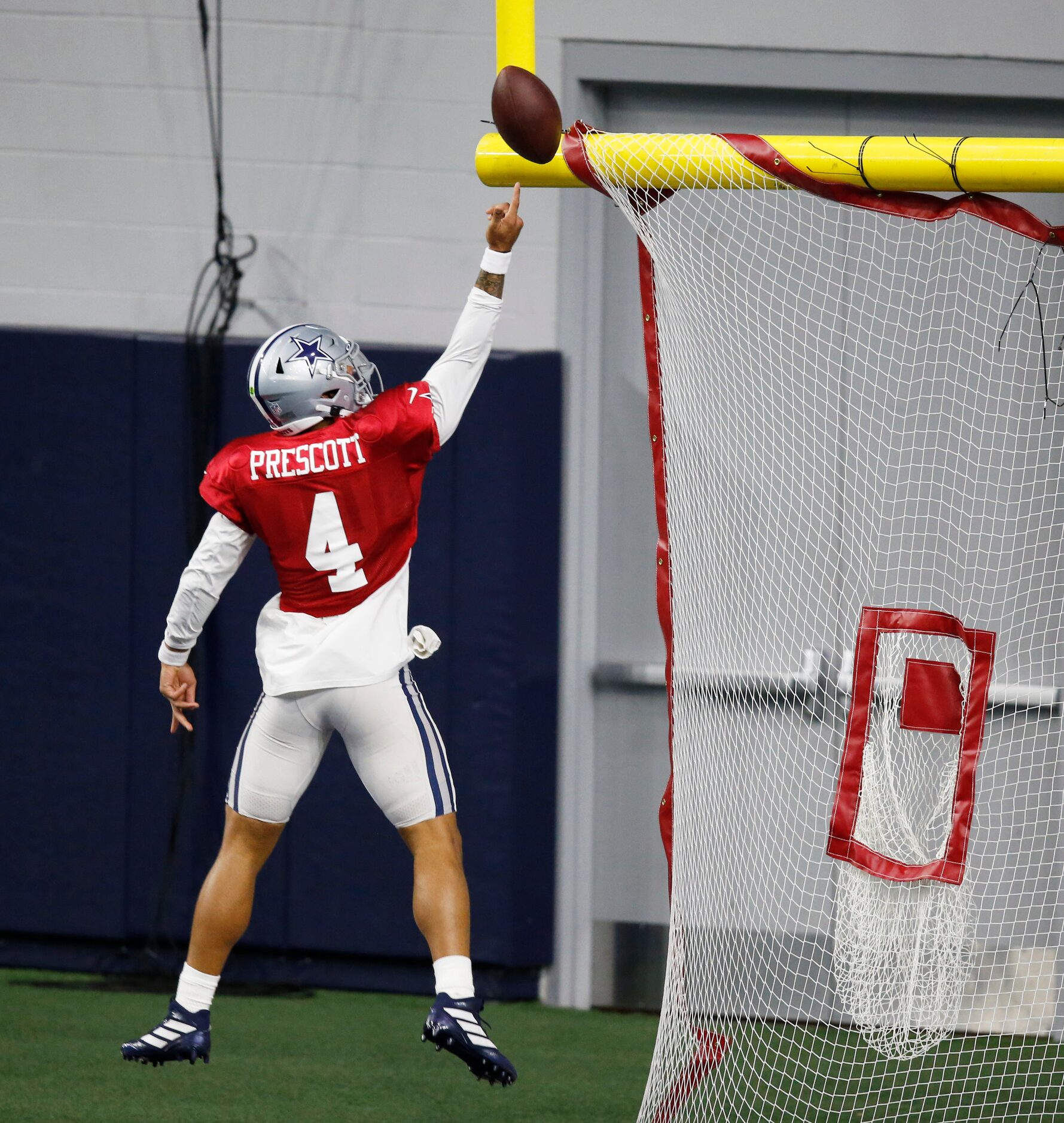 Dallas Cowboys quarterback Dak Prescott (4) leaps to toss the ball over the field goal post...