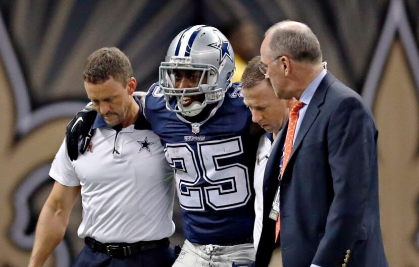 Dallas Cowboys running back Lance Dunbar (25) is carried off the field after a possible...