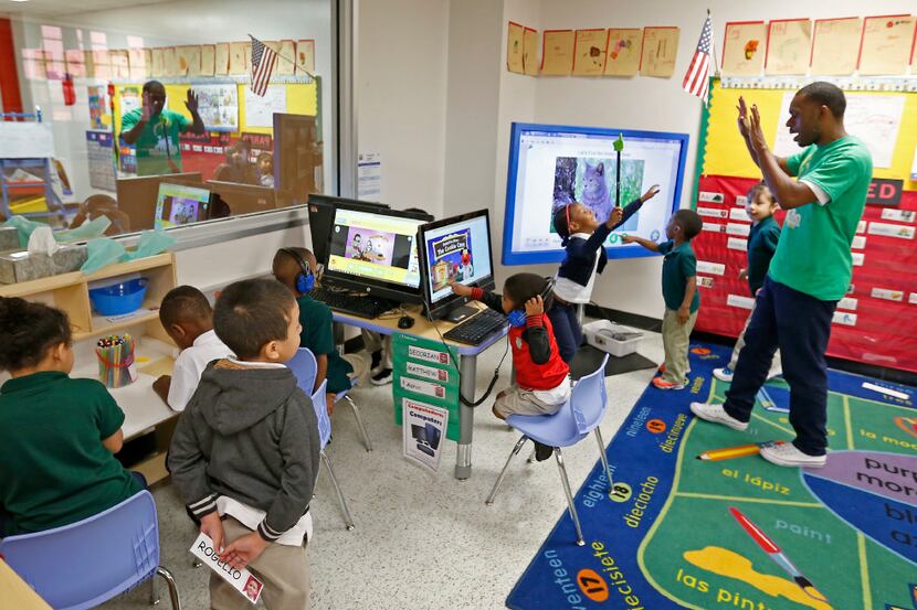 Teacher Traven Webb (right) plays with his Pre-K students in a classroom at N.W. Harllee...