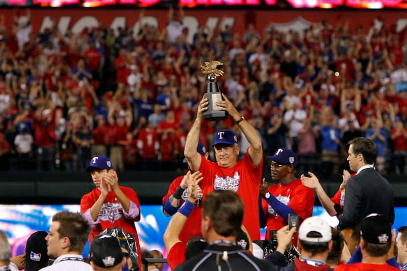 Texas Rangers president Nolan Ryan holds up the American League Championship trophy during...