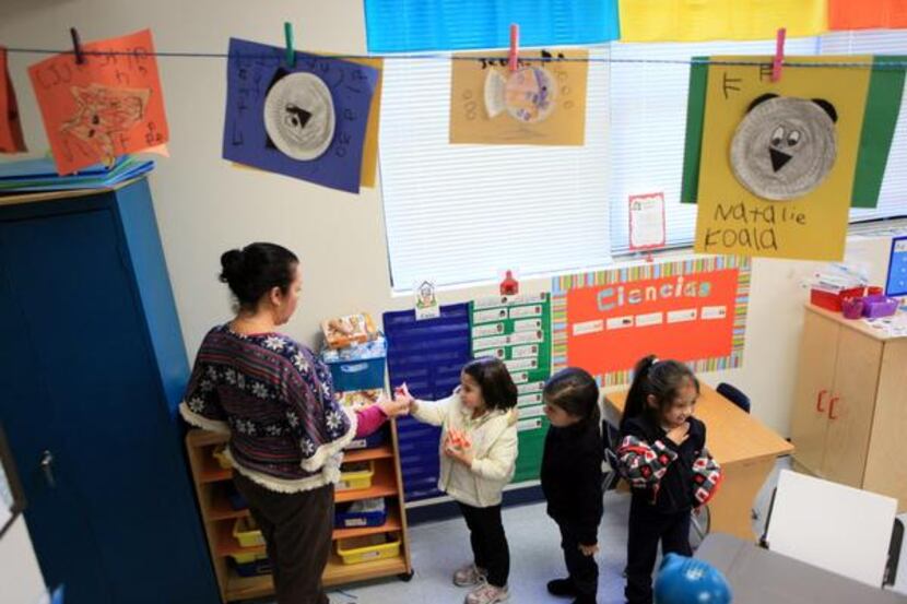 
Pre-k Teacher aid Sara Gomez, left, hands out food and drinks during a snack time break, on...