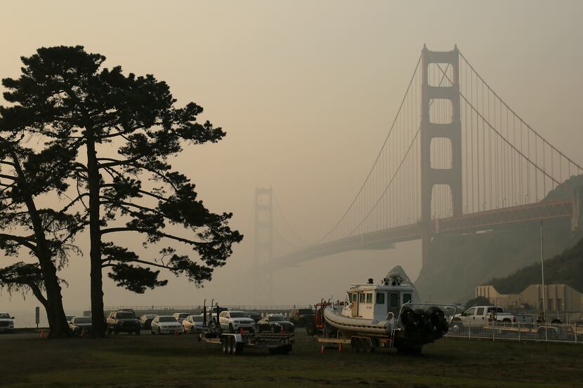 The Golden Gate Bridge is obscured by smoke and haze from wildfires Friday.