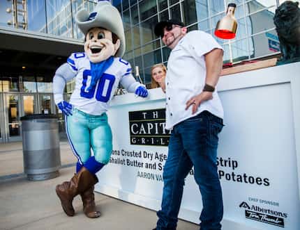 Dallas Cowboys mascot Rowdy poses with Aaron Valmont, chef at The Capitol Grill, at Taste of...