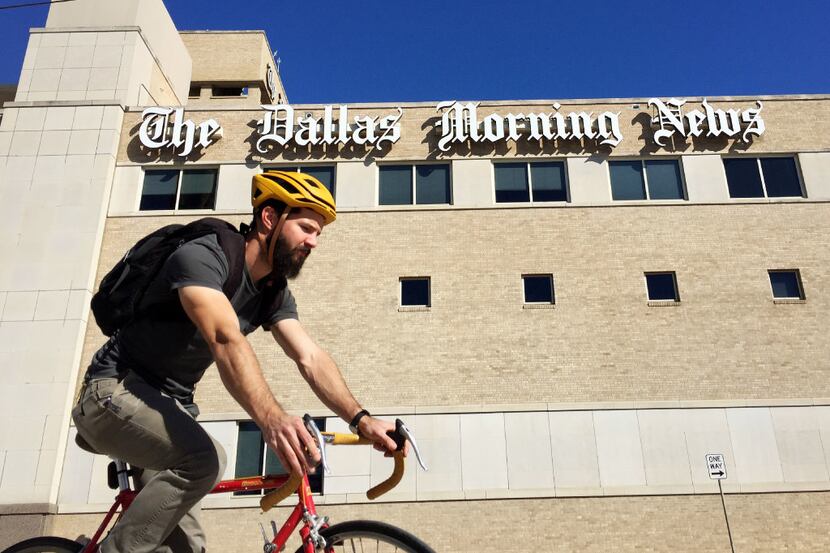 A bicyclist rides along the Houston Street viaduct in front of The Dallas Morning News...