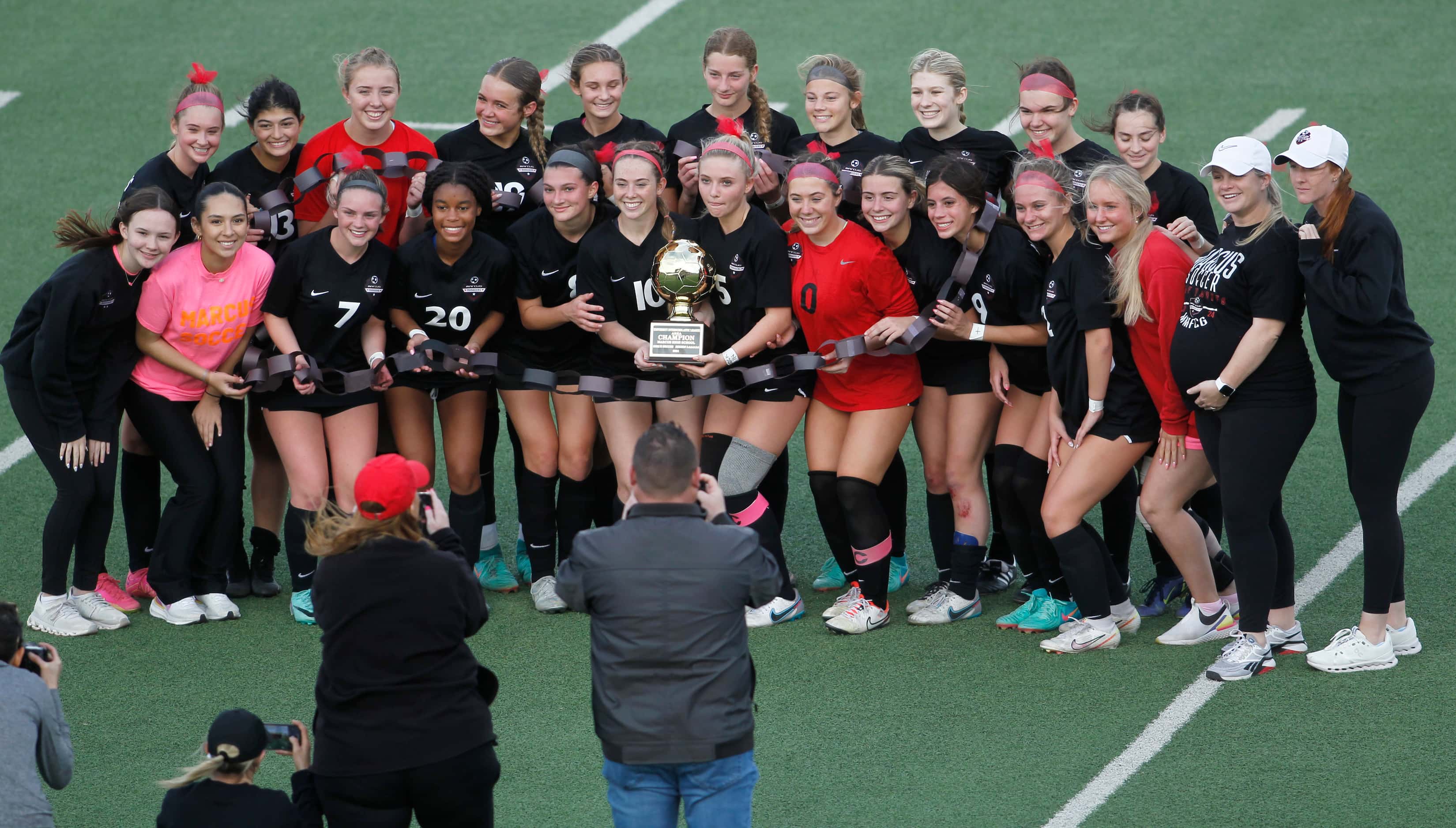 Flower Mound Marcus girls soccer players and coaches pose for a photo with their Area...