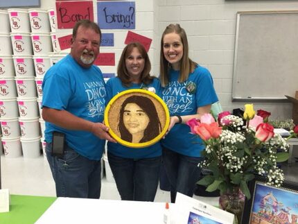 Michael and Dawn Sterling with Lisa Barker (right), holding the floragraph of the Sterlings'...