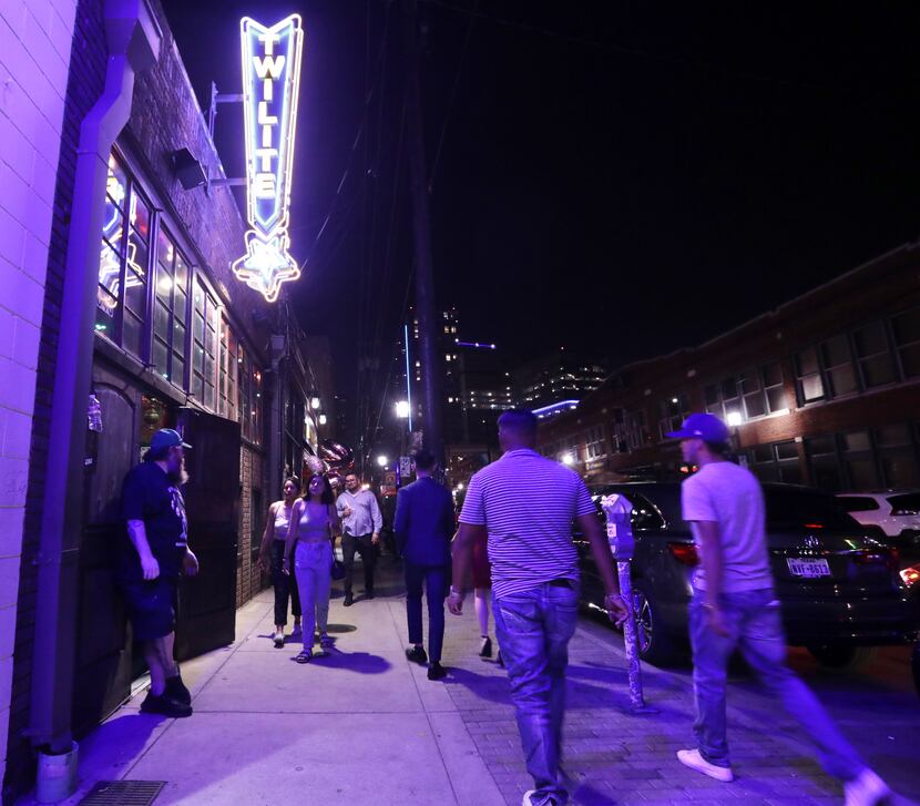 People look for food, drinks, music, and fun as they walk the streets of Deep Ellum in...
