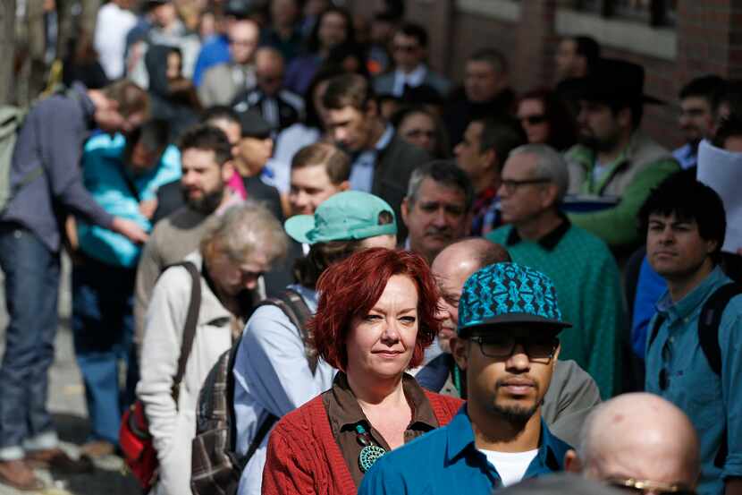 FILE - In this Thursday March 13, 2014, file photo, job seekers line up to attend a...