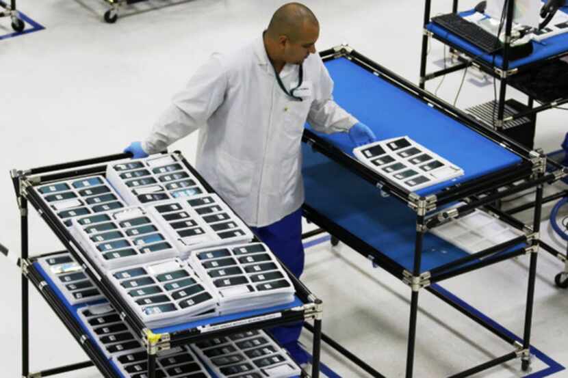  A worker at Motorola/Flextronics' manufacturing plant in Fort Worth in 2013. (Louis...