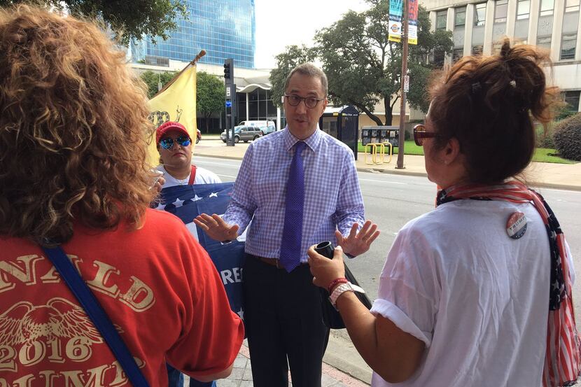 Dallas Morning News editor Mike Wilson speaks with pro-Trump protesters outside the newspaper.