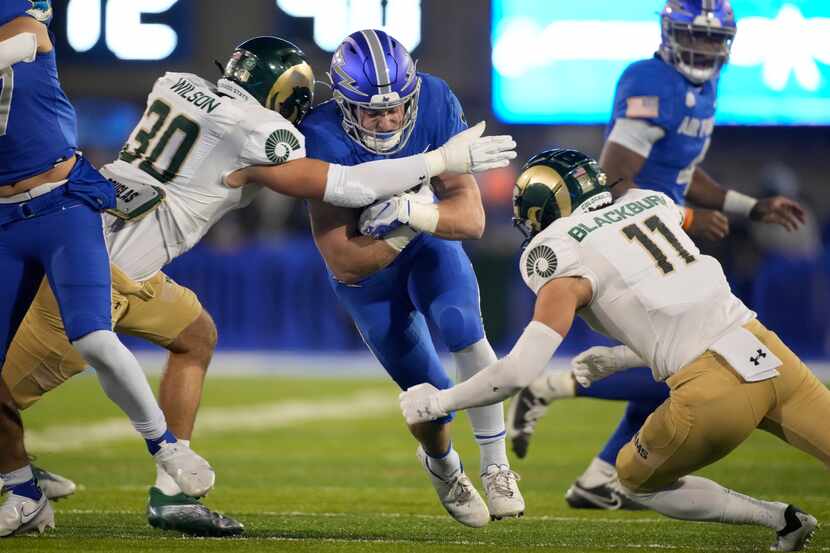 Air Force running back Brad Roberts, center, is stopped after a short gain by Colorado State...