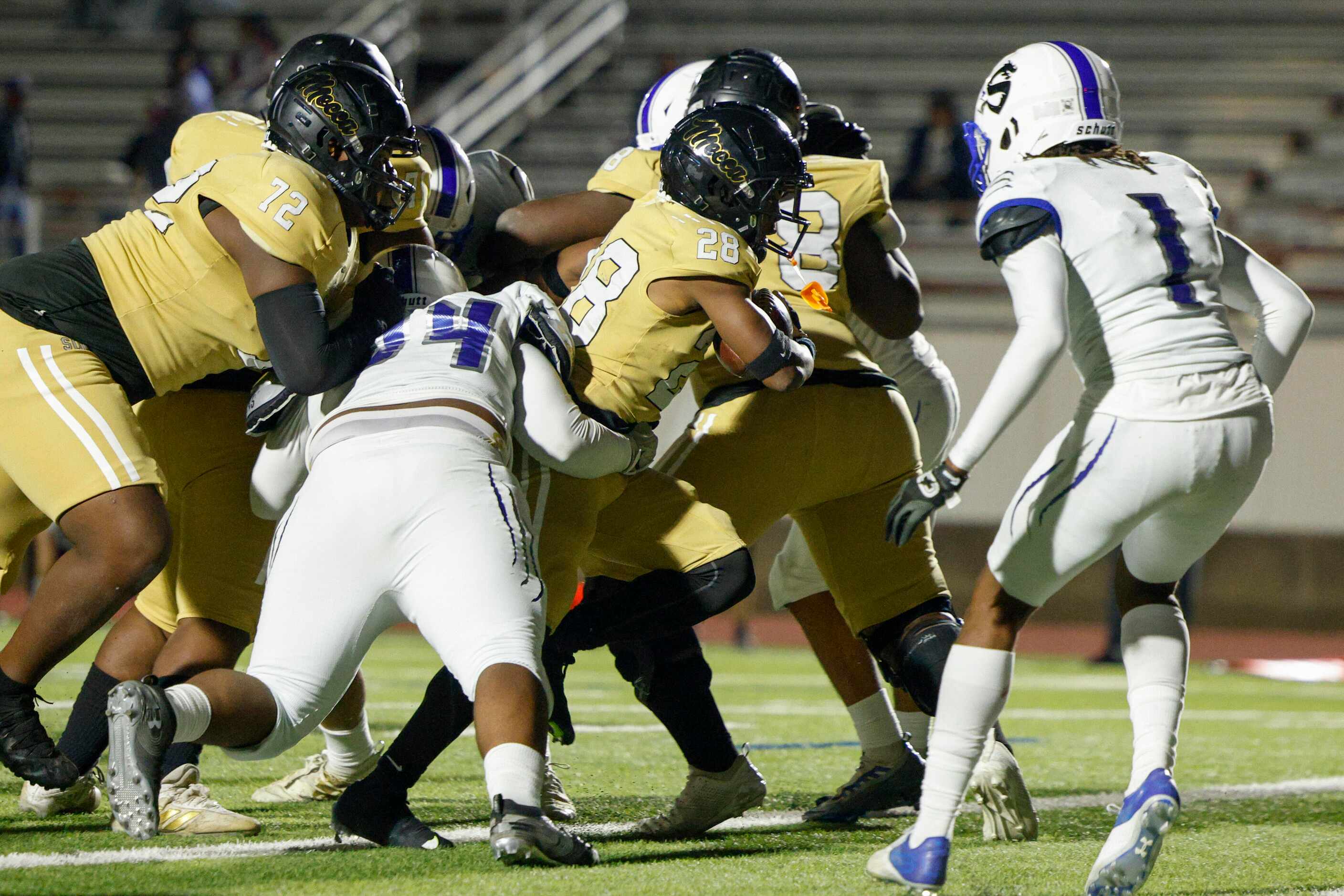 South Oak Cliff running back Izale Williams (28) runs through the arms of Seagoville...