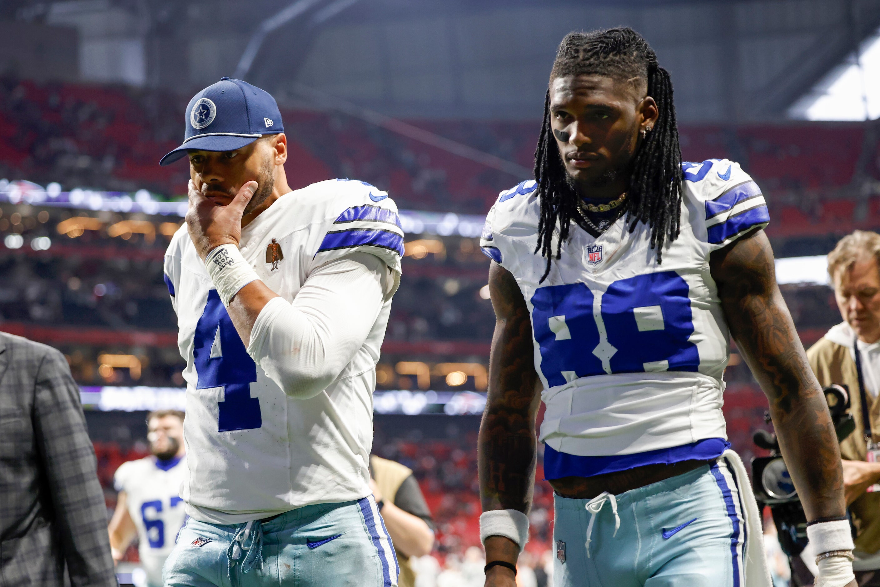 Dallas Cowboys quarterback Dak Prescott (4) and wide receiver CeeDee Lamb (88) walk off the...