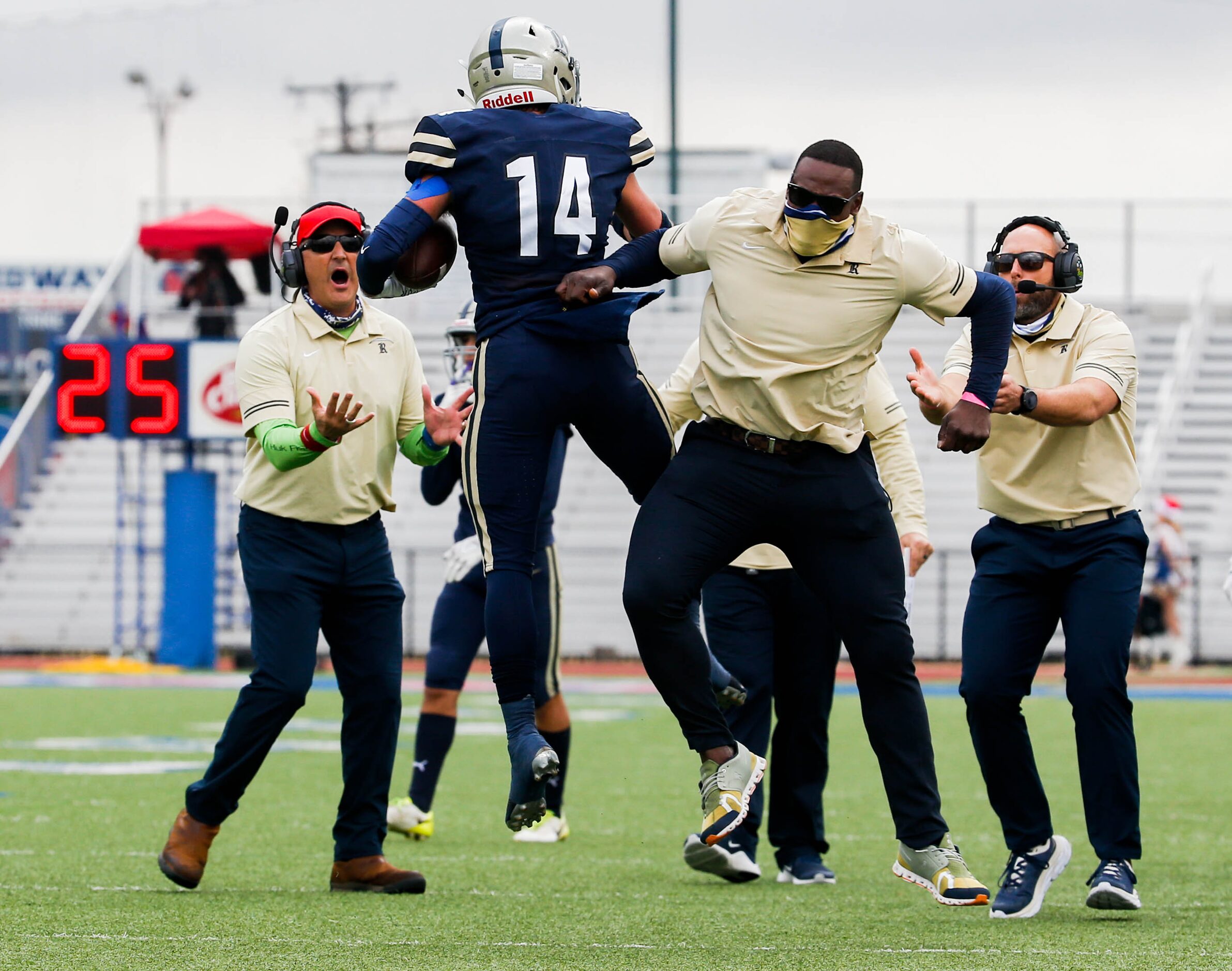 Austin Regents's Bryce Mountain (14) celebrates his interception with coaches against Dallas...