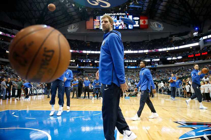 FILE - Mavericks forward Dirk Nowitzki and his teammates warm up before a game against the...